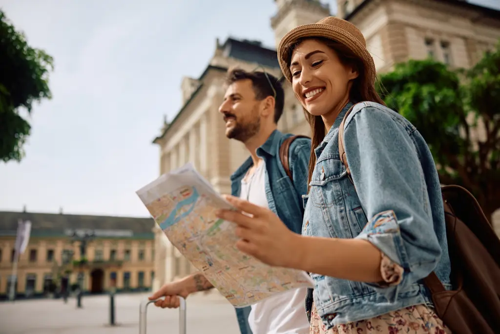 Une femme heureuse et son petit ami regardent une carte tout en explorant une ville un week-end pour la Saint Valentin. 