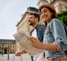 Une femme heureuse et son petit ami regardent une carte tout en explorant une ville un week-end pour la Saint Valentin.