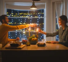 Un jeune couple heureux et amoureux prend un dîner romantique, trinque avec des verres de vin, mange un repas savoureux dans la cuisine, fait la fête et discute. Un beau mari et une belle femme passent un moment romantique.