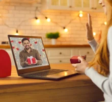 Un couple en relation à distance et rendez-vous virtuel sur un ordinateur. Un jeune couple amoureux s'appelle en vidéo pendant la saint-valentin et montre les cadeaux qu'il a préparés pour la Saint-Valentin.